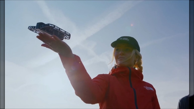 Woman holding her hand flat allowing a drone device to take flight