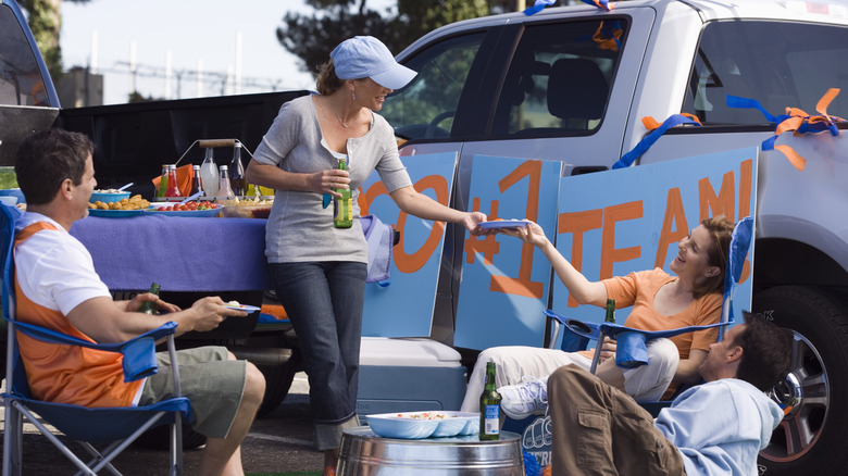 Group of people wearing orange and blue spiritwear at a tailgating event