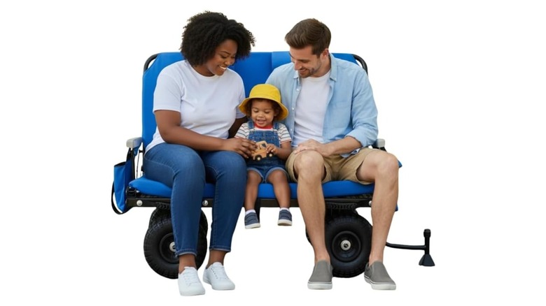 Couple with child sitting on a blue wagon on wheels