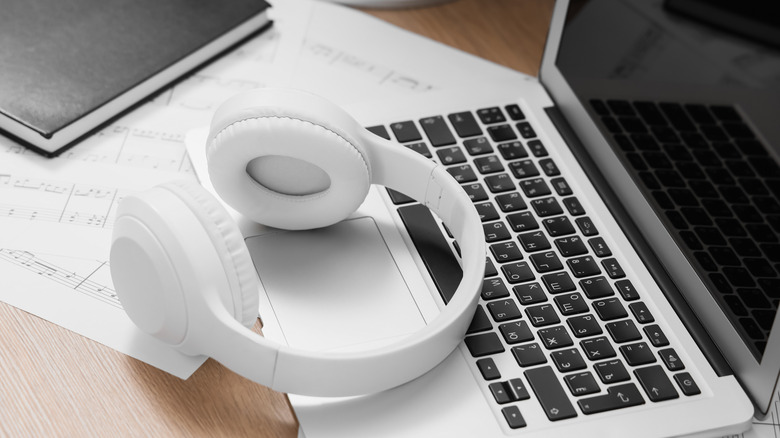 White wireless headphone on top of a laptop