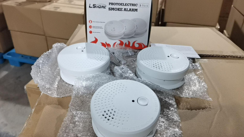 A bunch of smoke detector fire alarms out of a package.