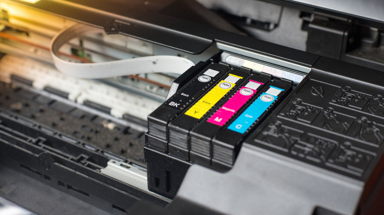 Open inkjet printer carriage displaying installed ink cartridges.