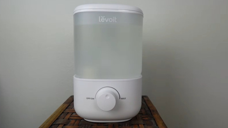 A white Levoit Humidifier resting on a woven surface