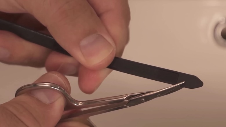 Person cutting notches in a zip tie