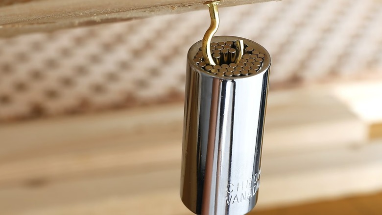 Universal socket screwing a metal hook into wood