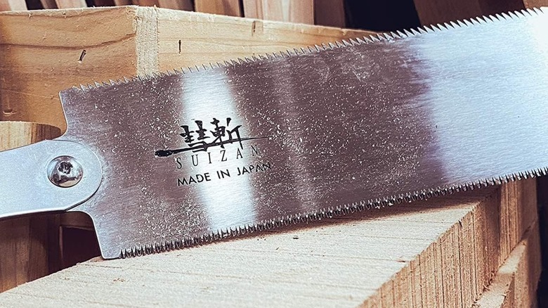 Suizan saw laid across a piece of lumber