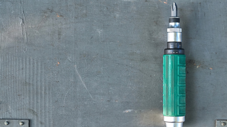 A hand impact driver against a gray background