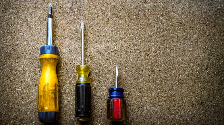 A multibit screwdriver next to other screwdrivers