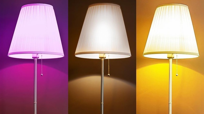 Three floor lamps side by side, each with a differently-colored bulb