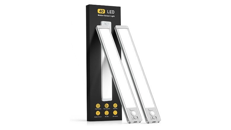 Two under cabinet lights, leaning up against their packaging, against a white background