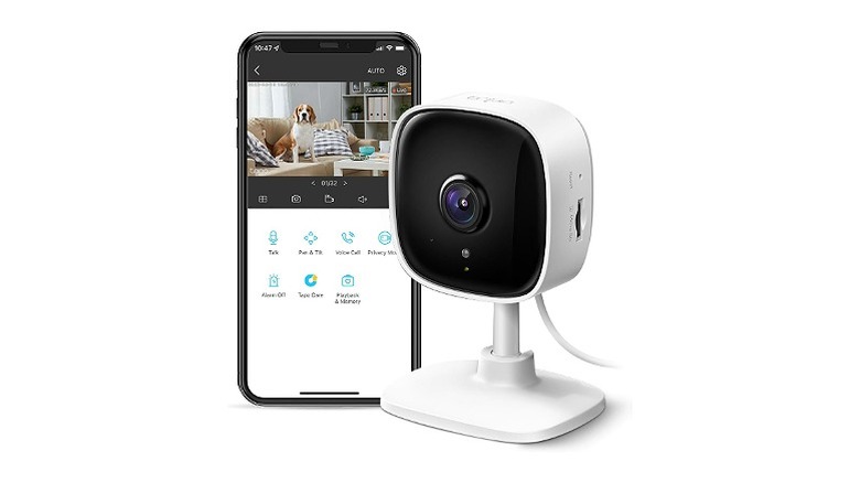 A TP-Link indoor camera next to a smartphone displaying its control app against a white background