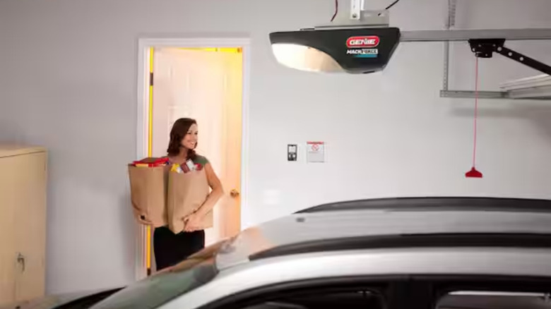 Woman walks into garage with Genie garage door opener visible