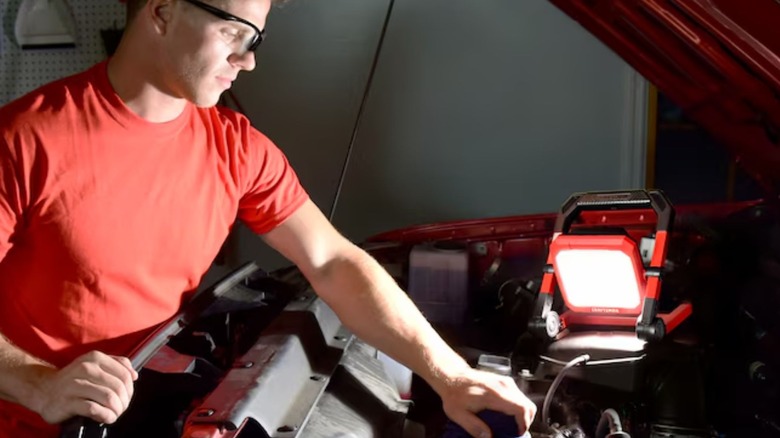 Man using Craftsman Portable Work Light to work on vehicle