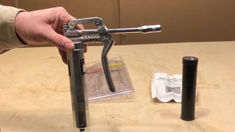 Person holding mini grease gun