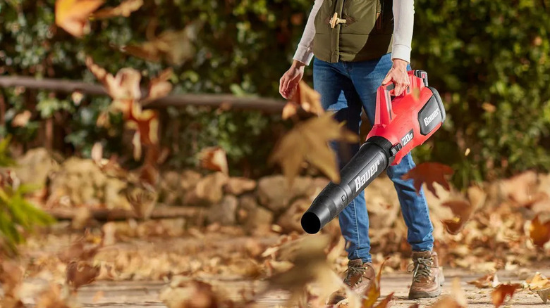 Homeowner using a Bauer blower on leaves.