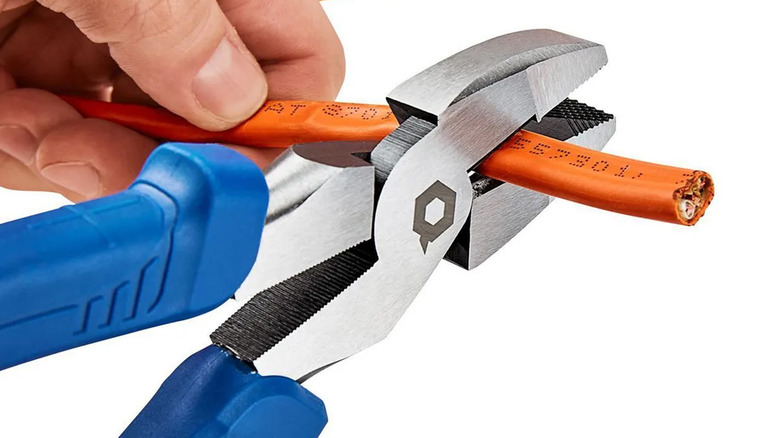 A person using Quinn pliers to cut a wire.