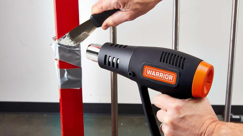 A man using a Warrior heat gun to unstick duct tape