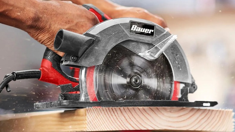 Cutting lumber with a Bauer circular saw.