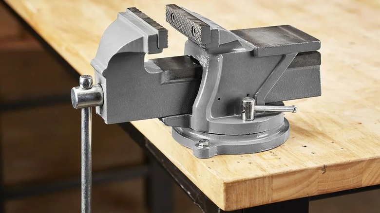 A Central Machinery vise attached to the edge of a workbench.
