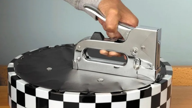 A worker using Fasten-Pro tacking gun on a flat surface