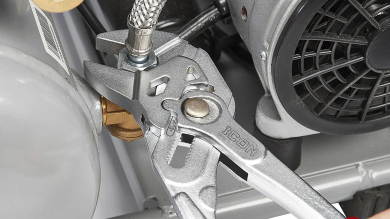 A person using an Icon pliers wrench to tighten a hose.