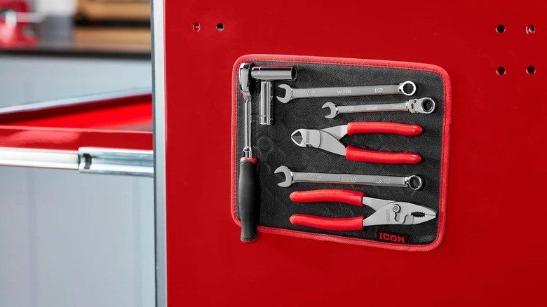 magnetic tool pad, holding several hand tols, on side of metal worktop