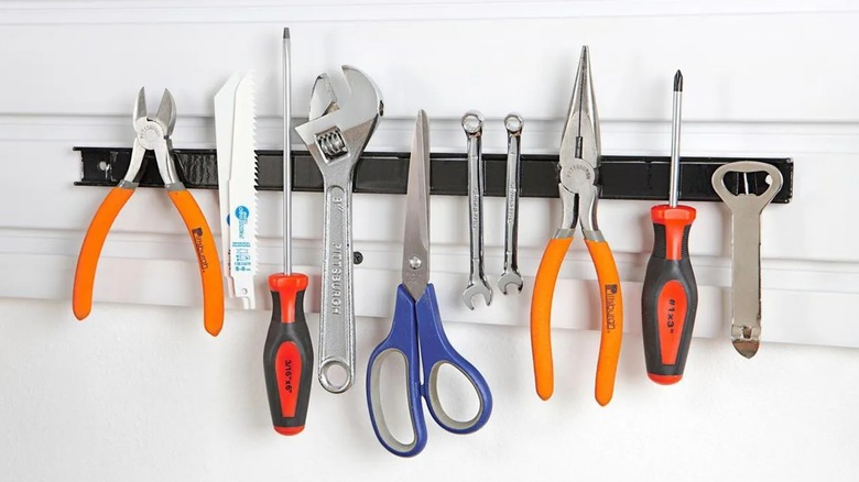 magnetic tool holder on a wall holding several metal tools