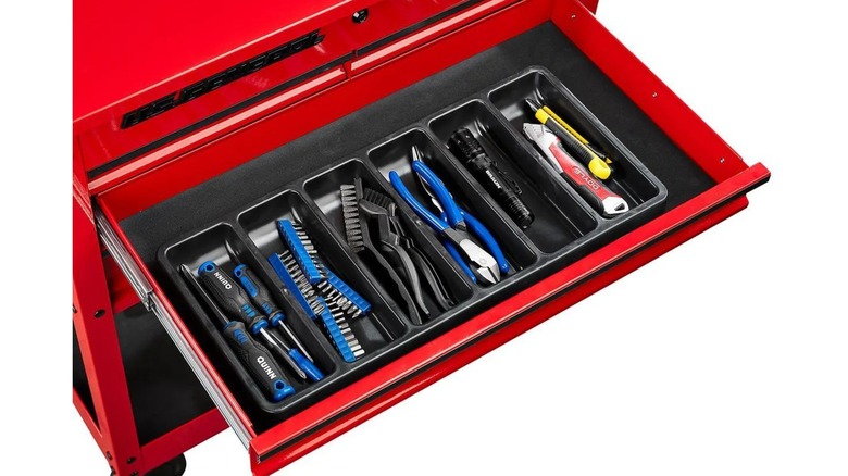 drawer organizer filled with tools against a white background