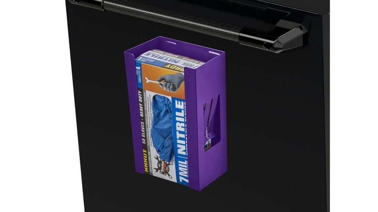 glove/tissue dispenser on the side of a metal workbench holding a box of gloves