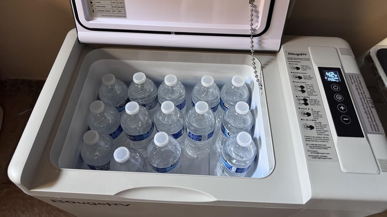 A BougeRV fridge cooling bottles of water at 42 degrees Fahrenheit