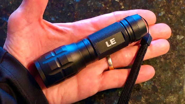 A person holding a Lighting Ever flashlight in their hand