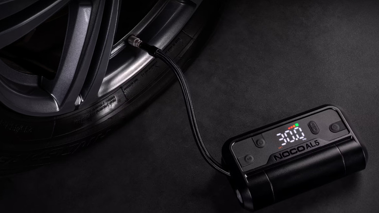A NOCO AL5 tire inflator pumping a tire