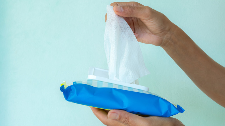 A person pulling out wet wipes from a pack