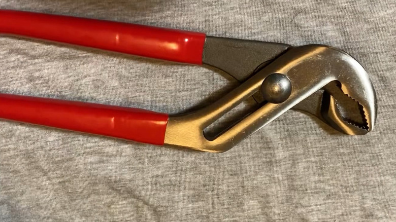 Groove Joint Pliers by Doyle placed on gray surface.