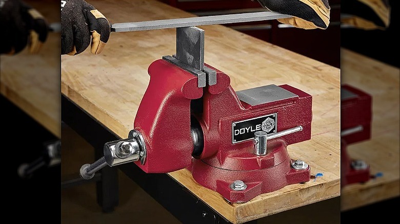 Using an swivel vise placed on a wooden table.
