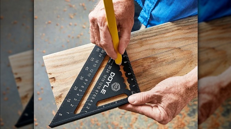 Using a rafter square to make markings on wood.