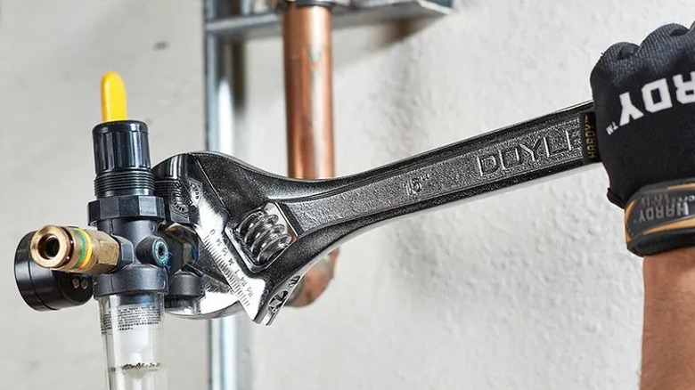 Using a wrench to work on a pipe.