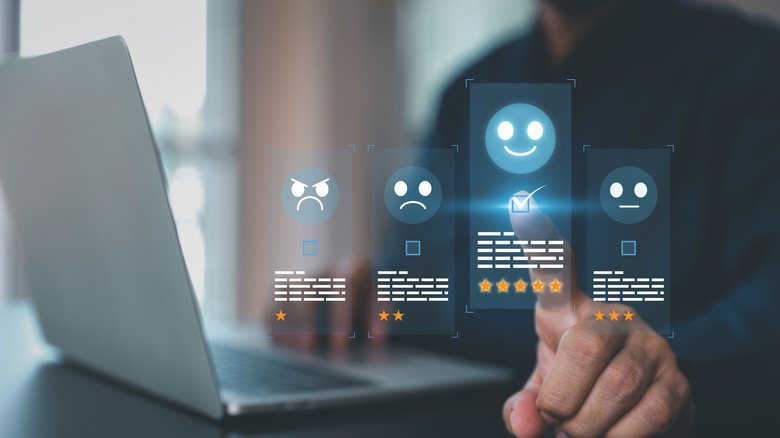 Holographic images of customer reviews and ratings above a laptop.