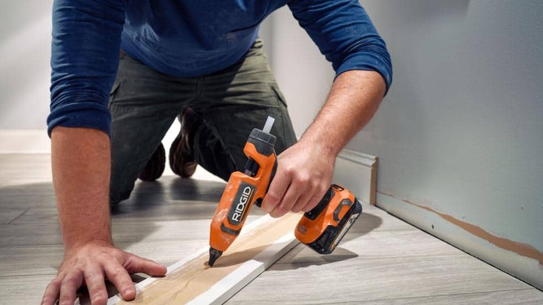 gluing baseboard with Ridgid glue gun