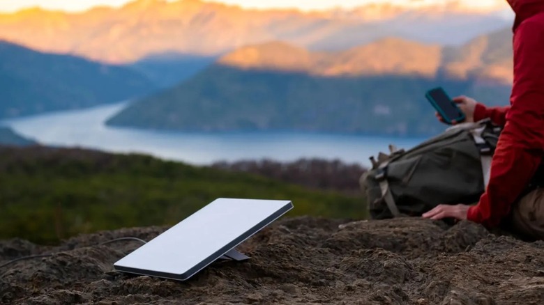 Woman using Starlink Mini Kit while hiking