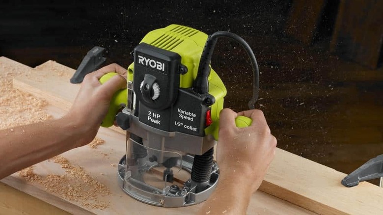 A plunge base corded router on a wooden board.