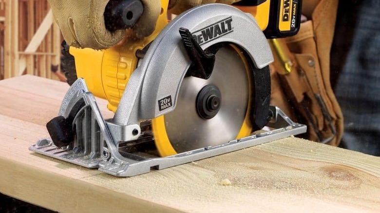 A circular saw cutting through a piece of wood.