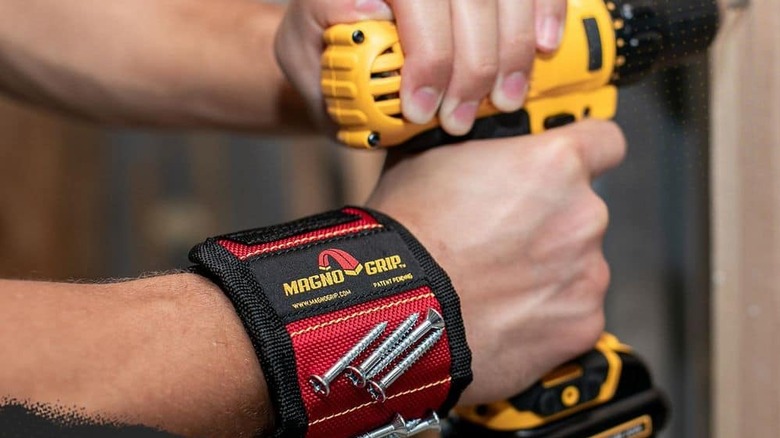 A magnetic wristband being worn while someone uses a power tool.