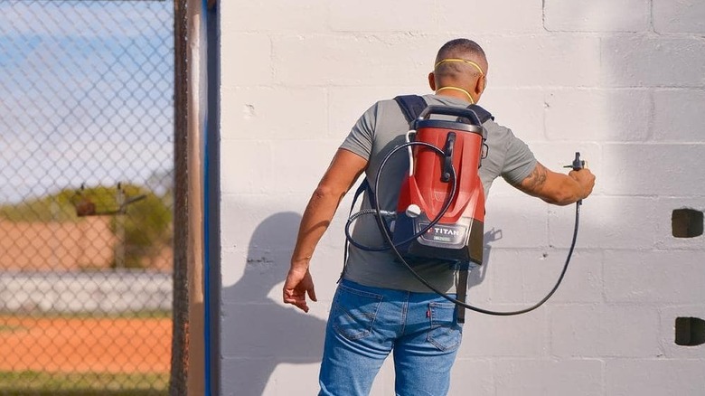 A man spray painting the wall.