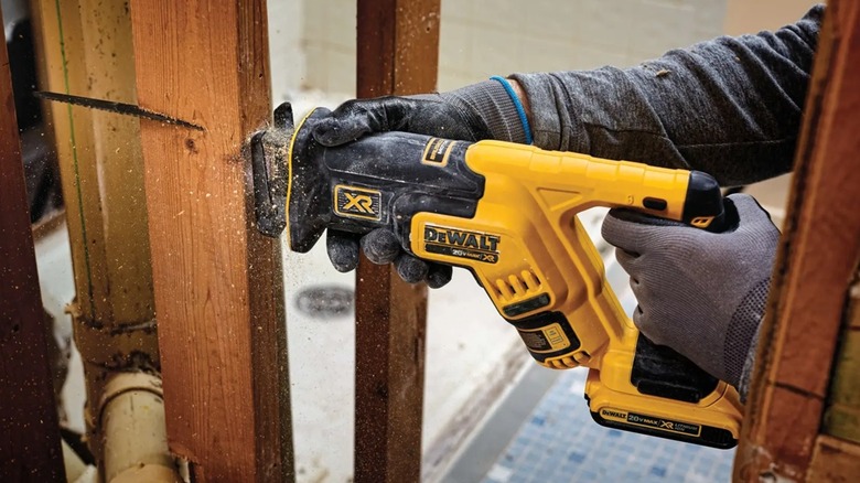 Person using DeWalt reciprocating saw