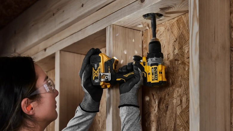 Person using DeWalt power drill