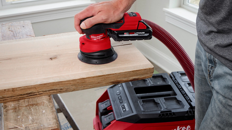 Person using Milwaukee sander