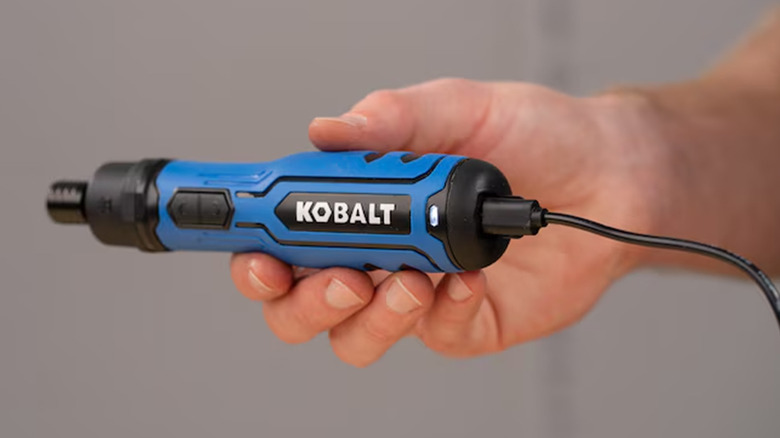 A person holding a Kobalt cordless electric screwdriver.