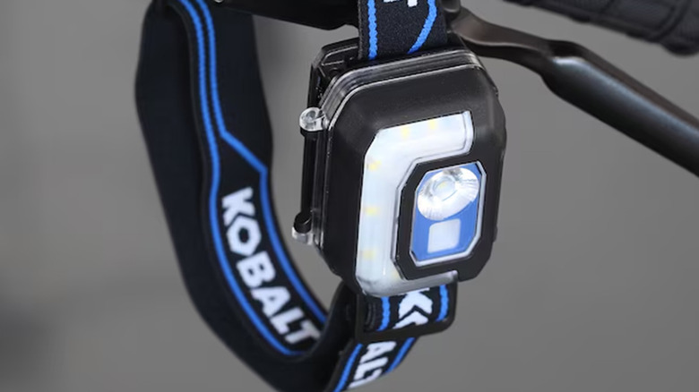 A Kobalt LED headlamp hanging on a bike handle.