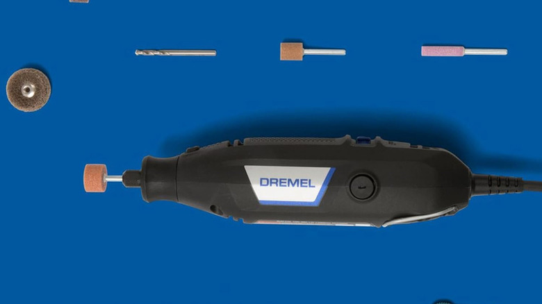 A Dremel 3100 model near some bits against a blue background